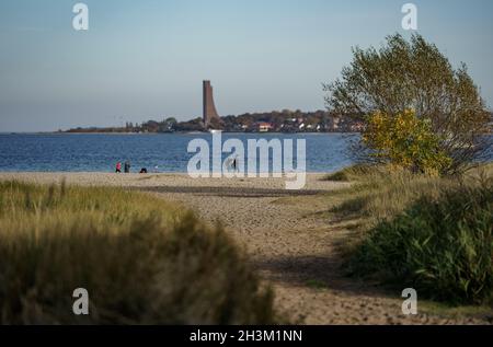 Kiel, Germany. 29th Oct, 2021. Walkers are out and about on the beach at Friedrichsort in the autumn sunshine. Credit: Axel Heimken/dpa/Alamy Live News Stock Photo