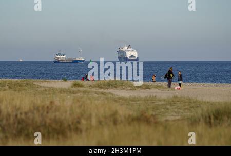 Kiel, Germany. 29th Oct, 2021. Walkers are out and about on the beach at Friedrichsort in the autumn sunshine. Credit: Axel Heimken/dpa/Alamy Live News Stock Photo