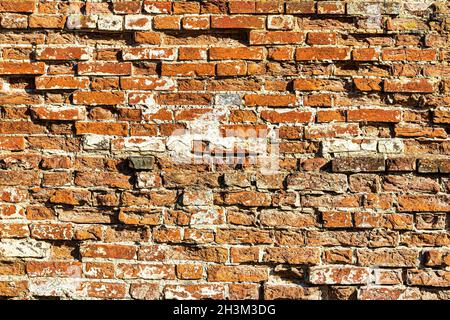 Wall texture from red old damaged bricks. Abstract background for design. Stock Photo