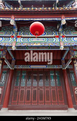Tibetan style door screen decorated with typical Chinese red paper lantern above door of the Gatehouse above the southern gate of the ancient city in the historic walled town / city of Songpan in Northern Sichuan, China (125) Stock Photo
