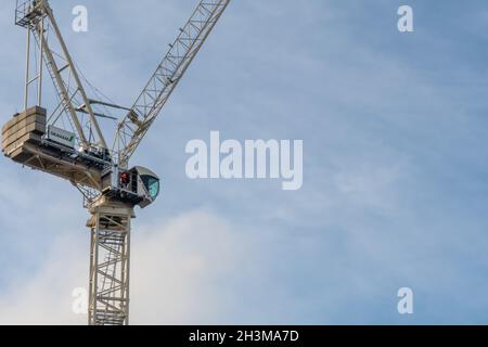 A tower crane operator leaves their cab at the end on a day's work. Stock Photo