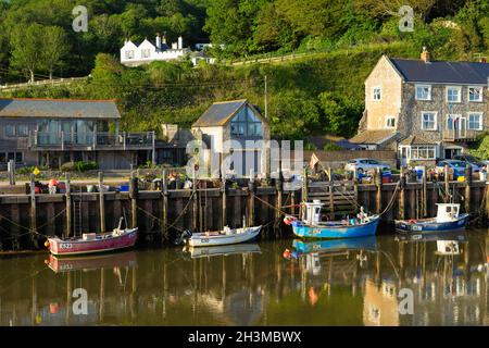 Fishing boats moored at Seaton Angling and Kayak Centre in Axmouth harbour on the River Axe at Haven Cliffs Seaton Devon England UK GB Europe Stock Photo