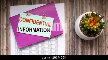 Confidential information text written on the table with documents. Stock Photo