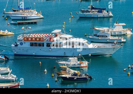 Tourist ferry boat to the Cinque Terre in motion in the port of the small Lerici town, tourist resort on the coast of the Gulf of La Spezia, Liguria. Stock Photo