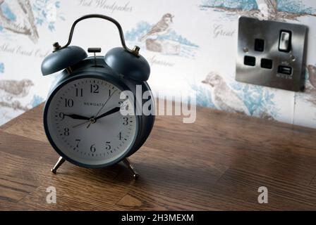 Old fashioned wind up alarm clock on side table in bedroom of pub and hotel The Devonport, in Middle One Row, Darlington, County Durham Stock Photo