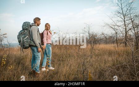 Couple Of Backpackers Travels Holding Hands In Nature Stock Photo