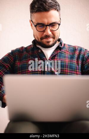 Happy man using laptop computer at home Stock Photo