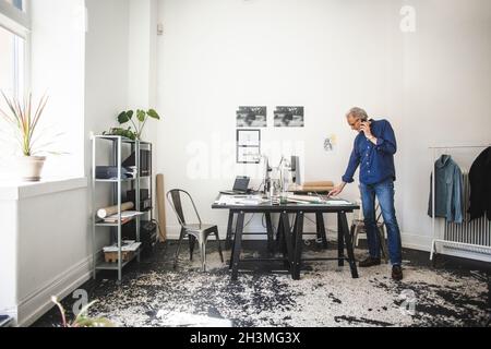 Male entrepreneur talking on mobile phone at workshop Stock Photo