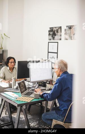 Female and male colleagues working on computer in office Stock Photo
