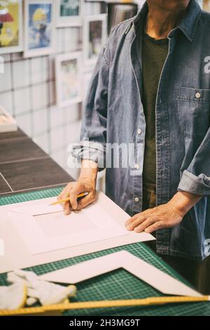 Midsection of craftsman with paper and pencil in retail shop Stock Photo