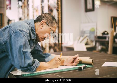 Male entrepreneur leaning while working at table in office Stock Photo