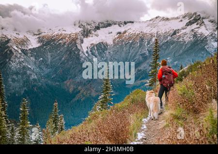 Female Hiker and Dog On A Trail In The North Cascade Mountains Stock Photo