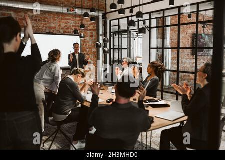 Business people applauding during meeting in board room Stock Photo