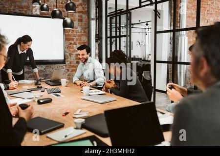 Cheerful male and female professional laughing during meeting in board room Stock Photo