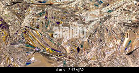 A sheet of crumpled aluminum foil with colored highlights Stock Photo