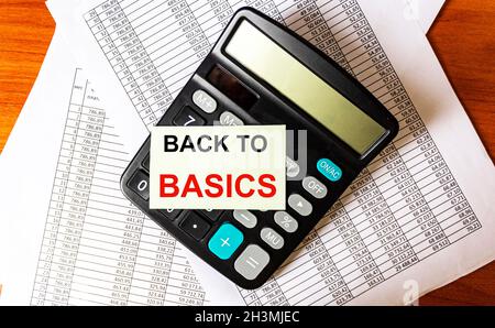 The phrase BACK TO BASICS on the sticker on the calculator and on documents with numbers Stock Photo