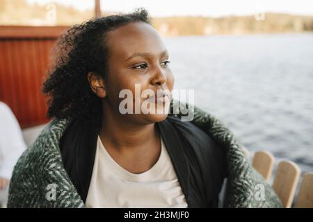 Smiling woman contemplating while looking away Stock Photo