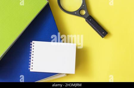 On a yellow background are folders for documents, a magnifying glass and a notebook for writing. Place to write Stock Photo