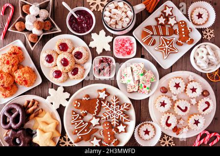 Christmas table scene of assorted sweets and cookies. Top view over a rustic wood background. Holiday baking concept. Stock Photo