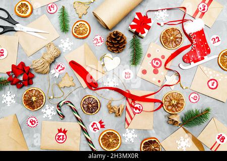 Preparing the Advent Calendar. Eco craft envelopes with gifts for children. Seasonal Christmas tradition. Flat lay, top view. Stock Photo