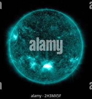 NASA's Solar Dynamics Observatory captured this image of a solar flare, as seen in the bright flash at the Sun's lower center, on October 28, 2021. The image shows a subset of extreme ultraviolet light that highlights the extremely hot material in flares and which is colorized here in teal. Solar flares are powerful bursts of radiation. Harmful radiation from a flare cannot pass through Earth's atmosphere to physically affect humans on the ground; however, when intense enough, they can disturb the atmosphere in the layer where GPS and communications signals travel. NASA/UPI Stock Photo