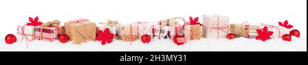 Christmas border of rustic red, white, brown and plaid gift boxes in snow. Side view isolated on a white background. Stock Photo