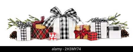 Assortment of many Christmas gift boxes with plaid wrap and ribbon and tree branches isolated on a white background Stock Photo