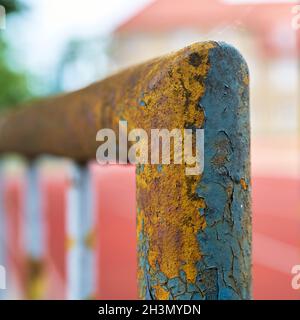 Paint flaking off an old dilapidated rusty fence Stock Photo