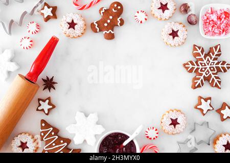 Christmas baking frame with cookies and sweets. Above view over a white marble background with copy space. Holiday baking concept. Stock Photo