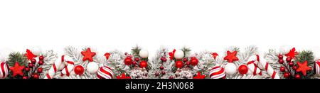 Long Christmas border of red and white ornaments and frosty branches isolated on a white background Stock Photo