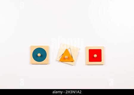 Colorful wooden Montessori sensorial material learning educational toys on white background. Geometric shape sorting board toys for baby kids. Top Stock Photo