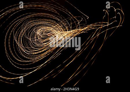 Golden colored lights in movements forming abstract shapes. Holiday concept. Stock Photo