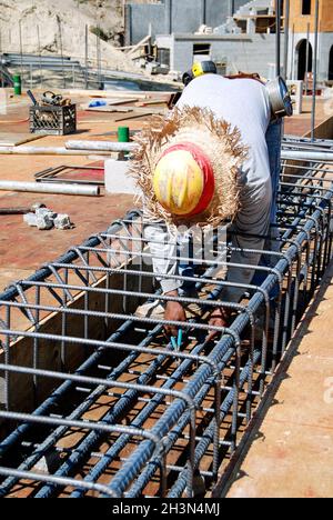 Concrete mason preparing a new steel grade beam for concrete Stock Photo