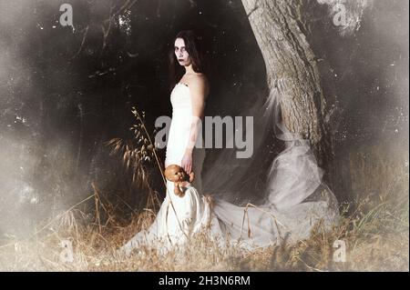 Horror Scene of a Woman Possessed holding a doll. Stock Photo