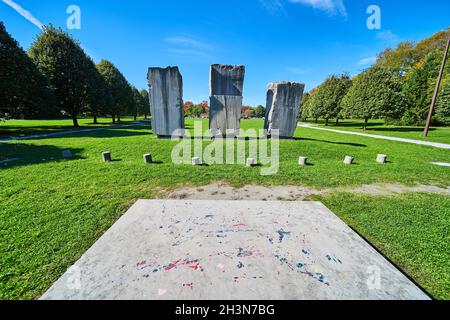 Open grass field with three large stone obelisk monuments Stock Photo