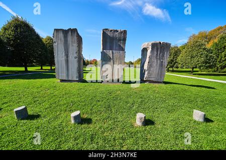 Three large stone obelisks in open green field Stock Photo