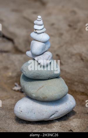 pebbles balanced in a tower formation on a beach in greece, pebbles or rocks in stack balancing one on top of the other to form a tower of stones. Stock Photo