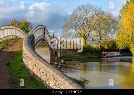 historic bridge over the grand union canal at braunston marina in northamptonshire uk. narrowboats on the canal in autumn season at braunston uk. Stock Photo