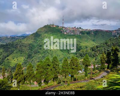 mountain city view with bright dramatic sky at morning from flat angle image is taken at kurseong darjeeling india. Stock Photo