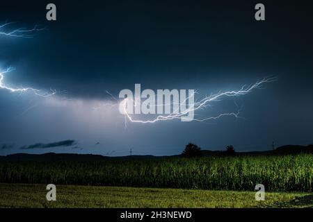 Lightning discharge in the air over a corn field in rural Transylvania, Romania Stock Photo
