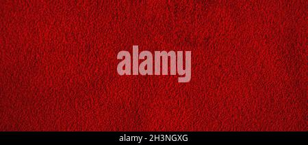Red matte background of suede fabric, closeup. Texture of seamless leather. Stock Photo