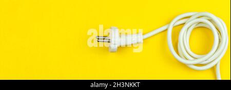 White electrical power cable on yellow background. EU plug, type. Flat lay, top view and copy space Stock Photo