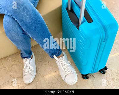 tourist legs in jeans and a blue travel bag Stock Photo