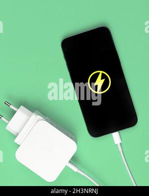 Charger mobile phone battery with power adapter. Flat lay, mint background, top view Stock Photo