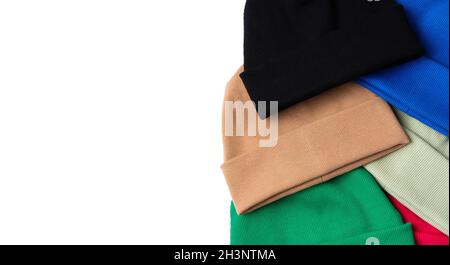 Youth warm stylish beanie hats of different colors for cool weather are laid out on a white background with a place for text Stock Photo