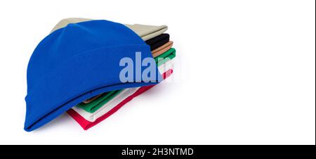 Blue, pink, green, white and black trendy warm beanie hats stacked on a white background with text. Stock Photo