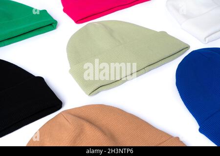 Stylish youth beanie hats, winter collection of bright colors laid out on a white background side view Stock Photo