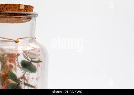 Bouquet of dry flowers and potpourri in a glass jar on a white table Stock Photo
