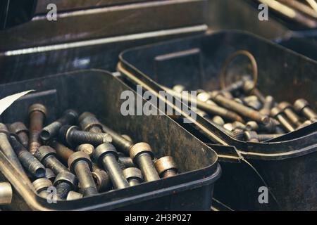 Sets of thick steel screws in plastic boxes. Industrial factory material, vintage effect Stock Photo