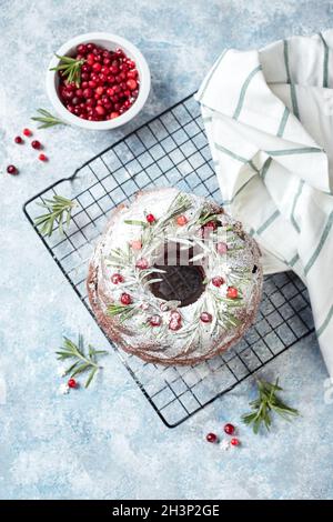 Christmas homebaked dark chocolate bundt cake decorated with powdered sugar and fresh berries Stock Photo